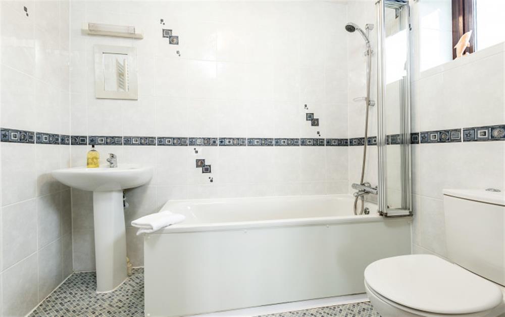 Th en-suite to the third bedroom double room has both a bath and overhead electric shower. at Penthouse in Maenporth