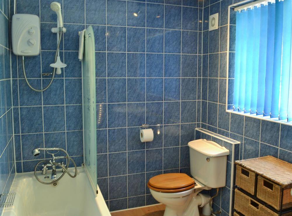 Bathroom featuring shower over bath, toilet and heated towel rail at Stable End, 