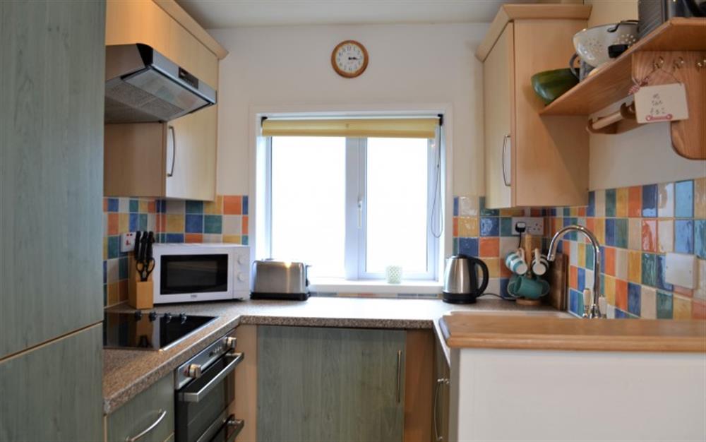 The kitchen is compact, but includes an oven, hob, microwave, dishwasher and washing machine. at Periwinkle in Helford Passage