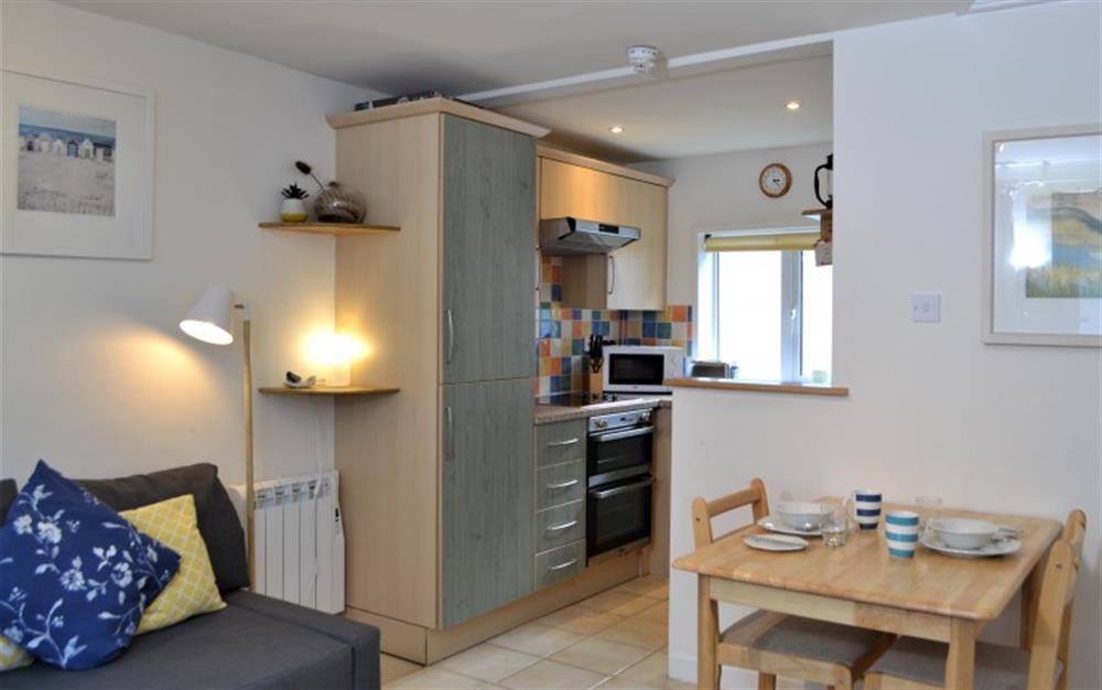 The open-plan living and dining area, with the colourful kitchen in the background. at Periwinkle in Helford Passage