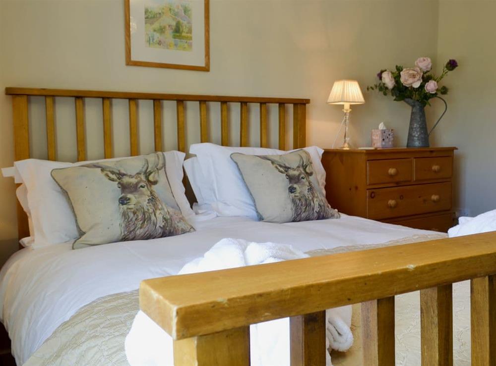 Bedroom with super kingsize bed at Perriwinkle Cottage in Great Longstone, near Bakewell, Derbyshire