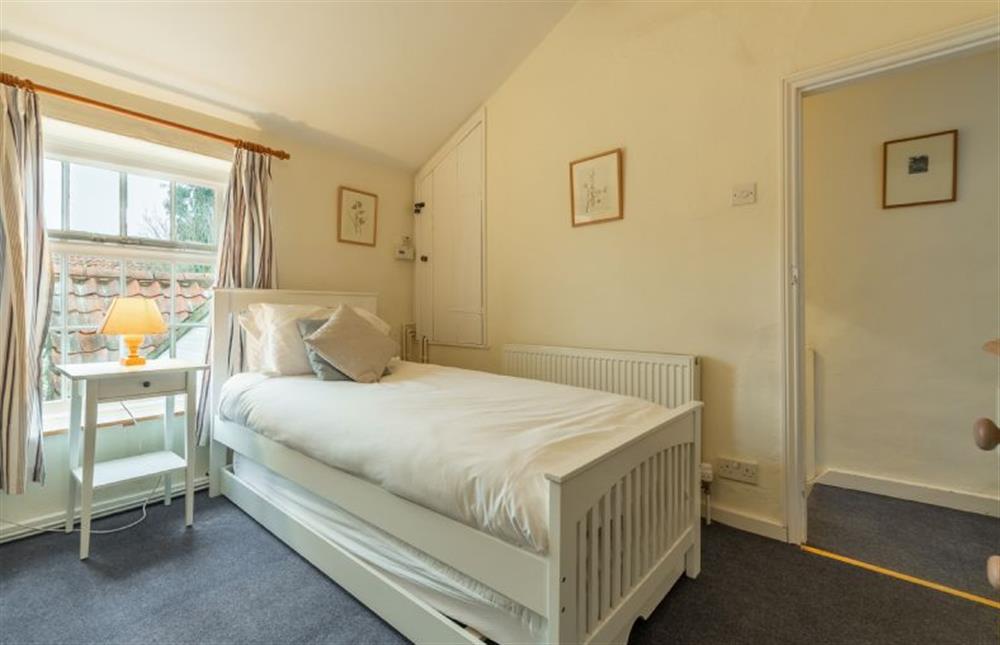 First floor: Spacious bedroom two has a single bed and truckle bed under at Petts Cottage, Burnham Market near Kings Lynn