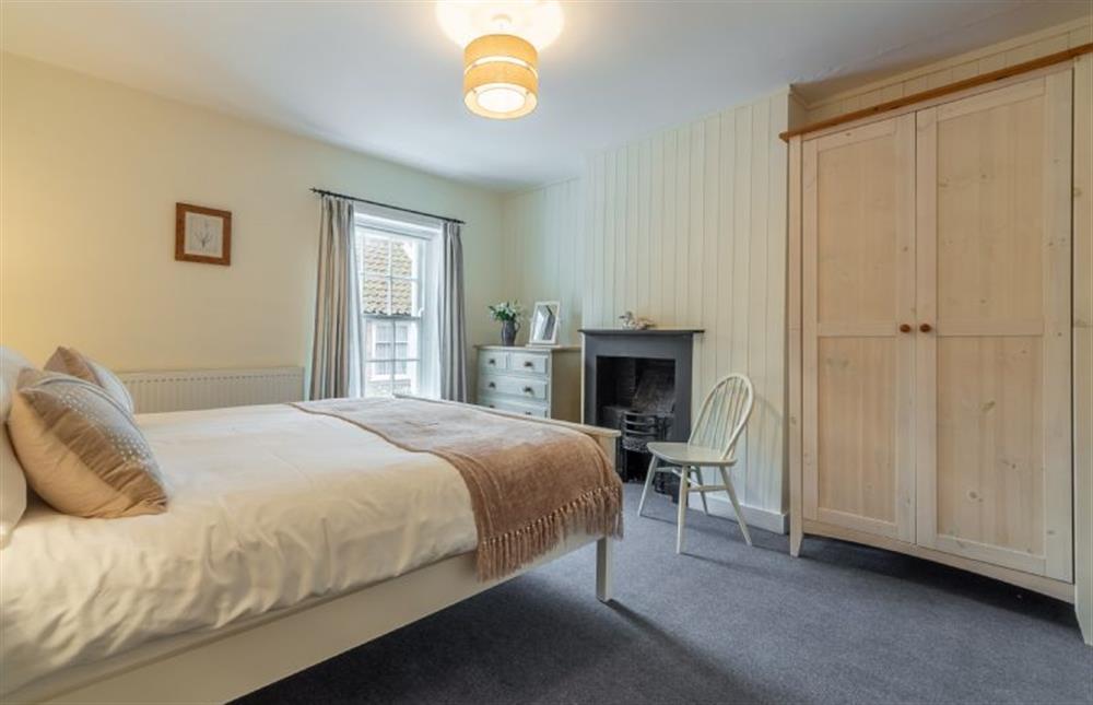 First floor: Spacious master bedroom has feature fireplace at Petts Cottage, Burnham Market near Kings Lynn