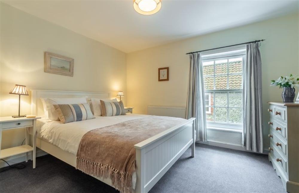 First floor: The master bedroom has a king-size bed at Petts Cottage, Burnham Market near Kings Lynn