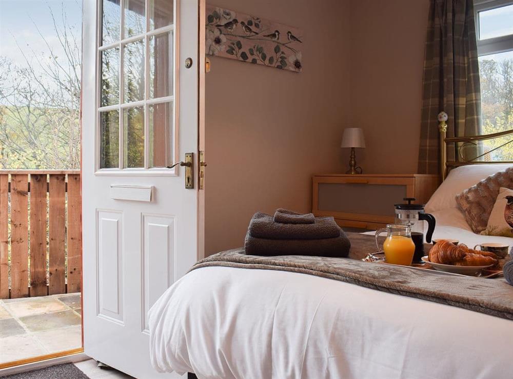 Light and airy bedroom with access to the sitting out area at Pheasant Lodge in Staithes, near Whitby, North Yorkshire