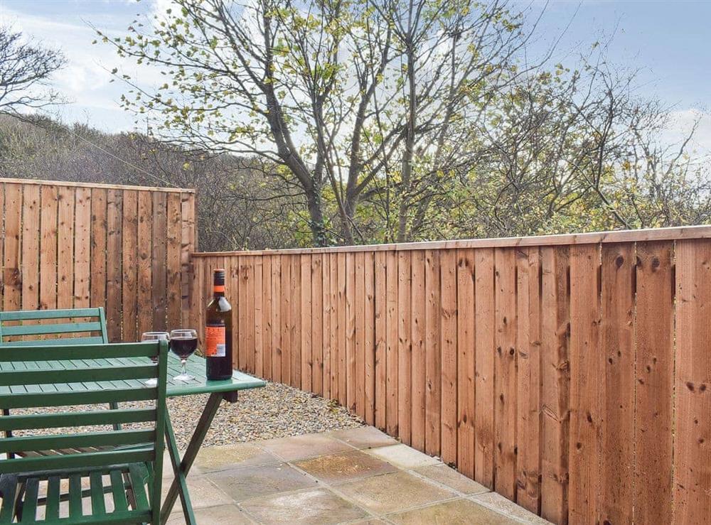 Private outdoor space with table and chairs at Pheasant Lodge in Staithes, near Whitby, North Yorkshire