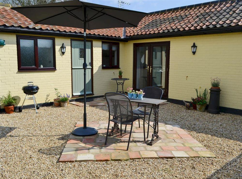 Enclosed courtyard with patio and garden furniture at Pheasant Lodge in Welborne, near Dereham, Norfolk