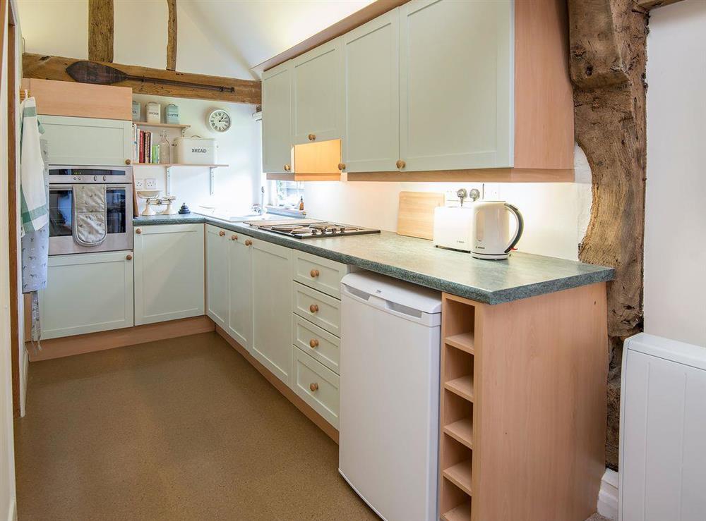 Charrming galley style kitchen at Pheasants Hill Old Byre in Hambleden, near Henley-on-Thames, Buckinghamshire, England
