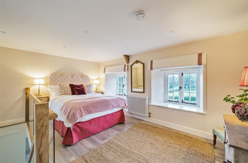 The king-size bedroom with views of the garden at Piddle Cottage at Piddle and Puddle, Dorchester