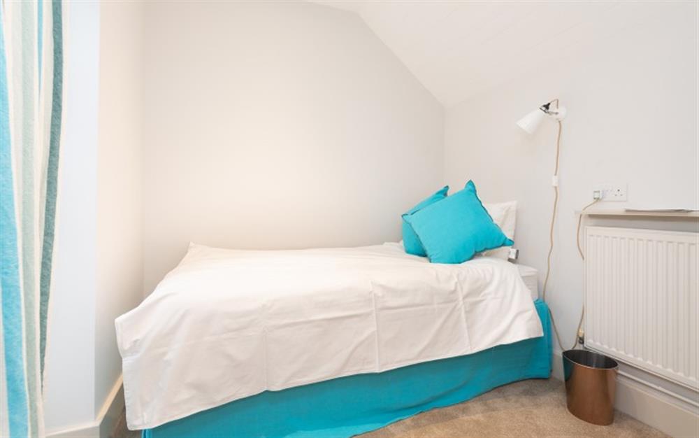 Single room with truckle bed under, and door to rear terrace at Pink Cottage in Noss Mayo