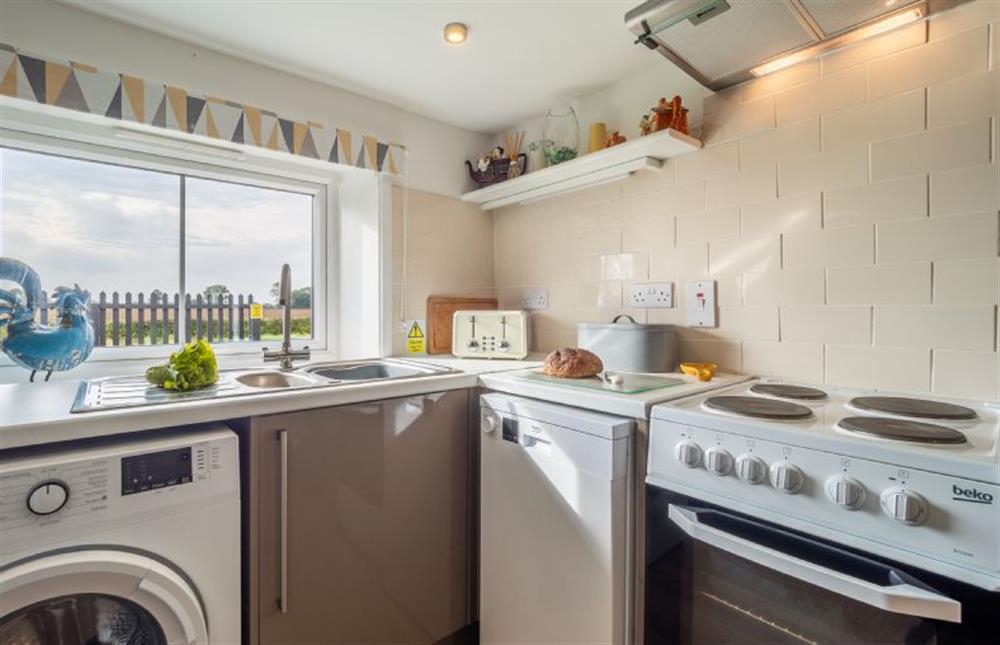 Kitchen with washing machine, dishwasher and electric oven at Pink Cottage, Stradbroke
