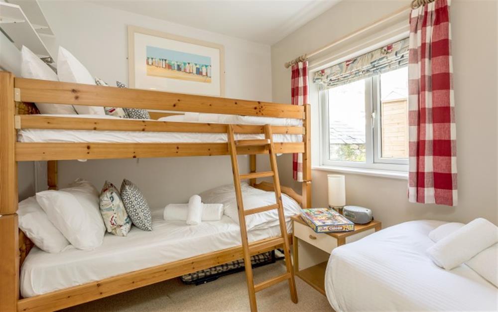 The second bedroom has bunk beds and a single bed. at Pirates Den in Helford Passage