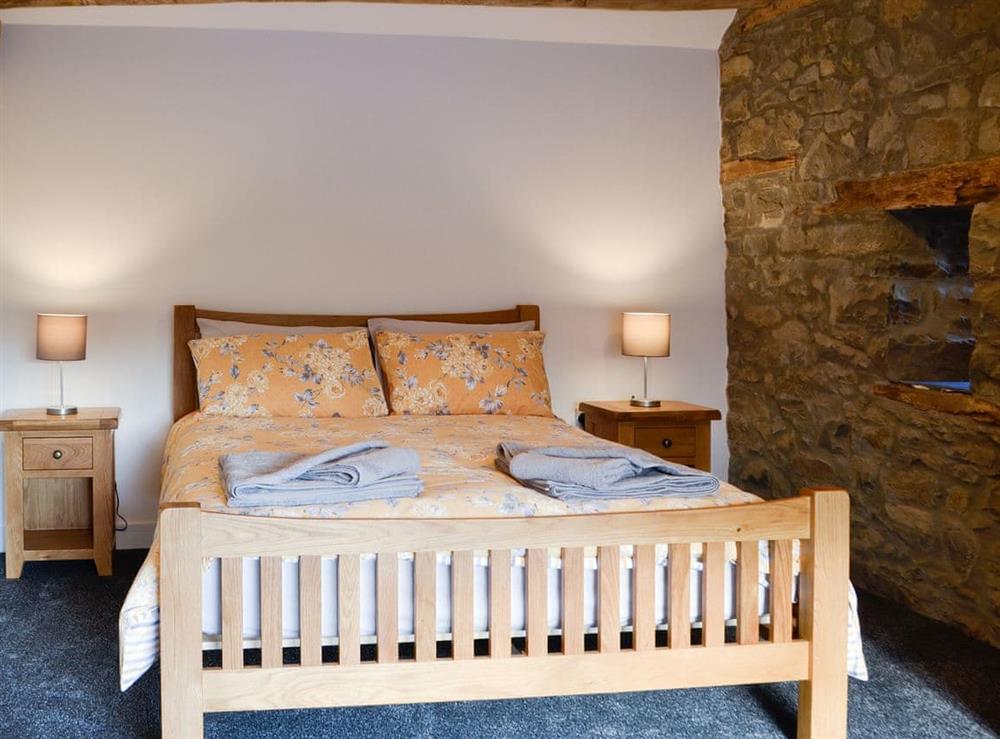 Lovely and romantic bedroom with exposed stone wall at Pistyll Gwyn in Llanwrthwl, near Rhayader, Powys