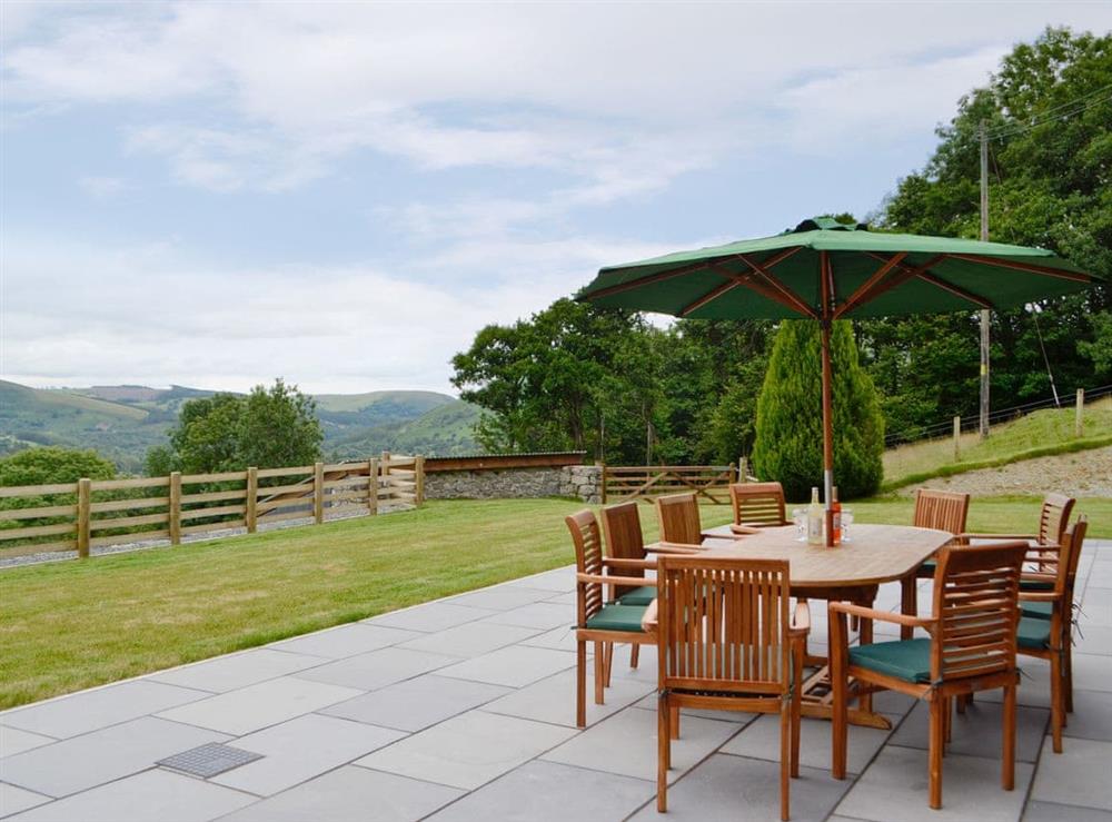 Paved patio area with outdoor furniture at Pistyll Gwyn in Llanwrthwl, near Rhayader, Powys