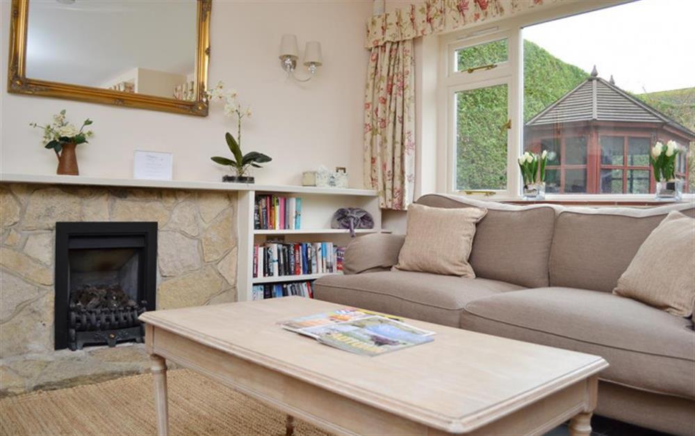 Living area with windows overlooking the garden at Pittefaux Cottage in Brockenhurst