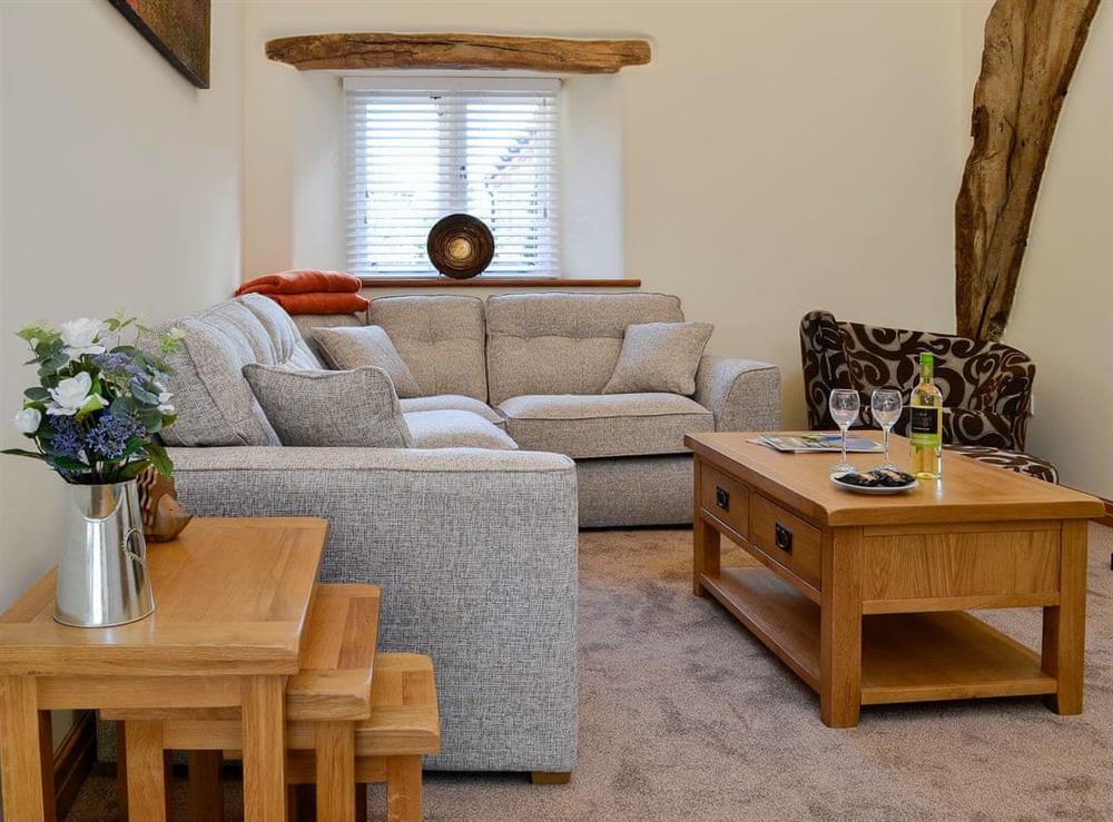 Welcoming living area with exposed woodwork and wood burner at Cruck Barn, 