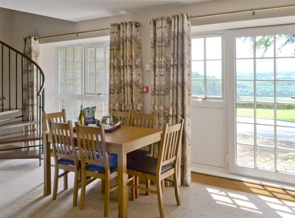 Dining area and spiral staircase at Plover Cottage in Sharperton, near Rothbury, Northumberland