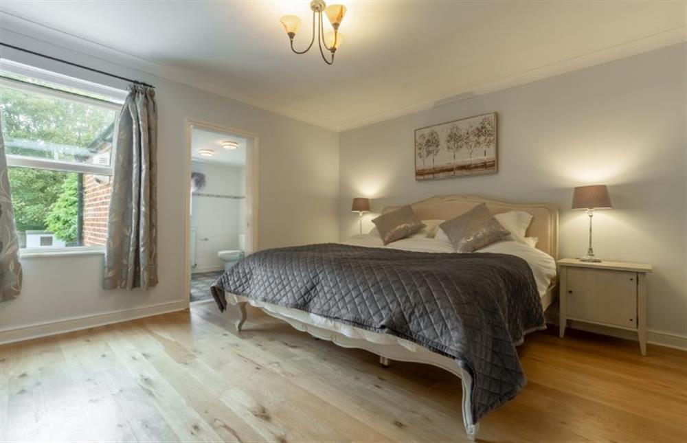 First floor: Master bedroom with super-king size bed and door to en-suite at Plum Cottage, Overstrand near Cromer