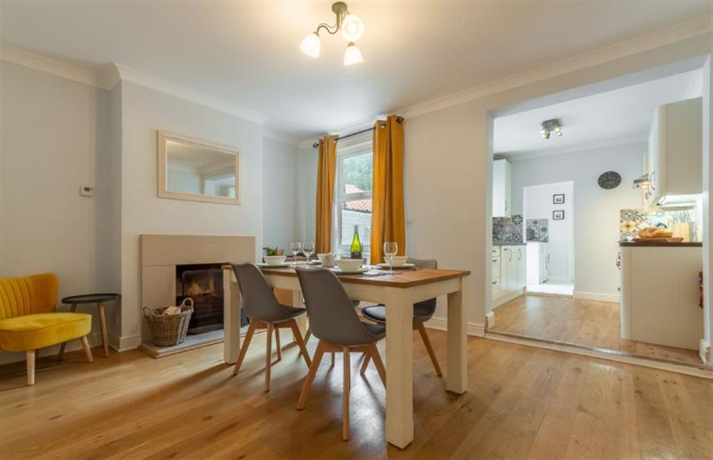 Ground floor: Dining room with open fire, looking through to kitchen at Plum Cottage, Overstrand near Cromer