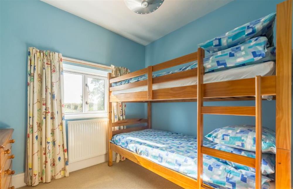 First floor: Bedroom three, spacious room with bunk beds at Plunketts Cottage, Brancaster near Kings Lynn