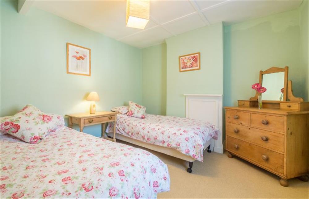 First floor: Bedroom two, pretty twin room with walk-in wardrobe at Plunketts Cottage, Brancaster near Kings Lynn