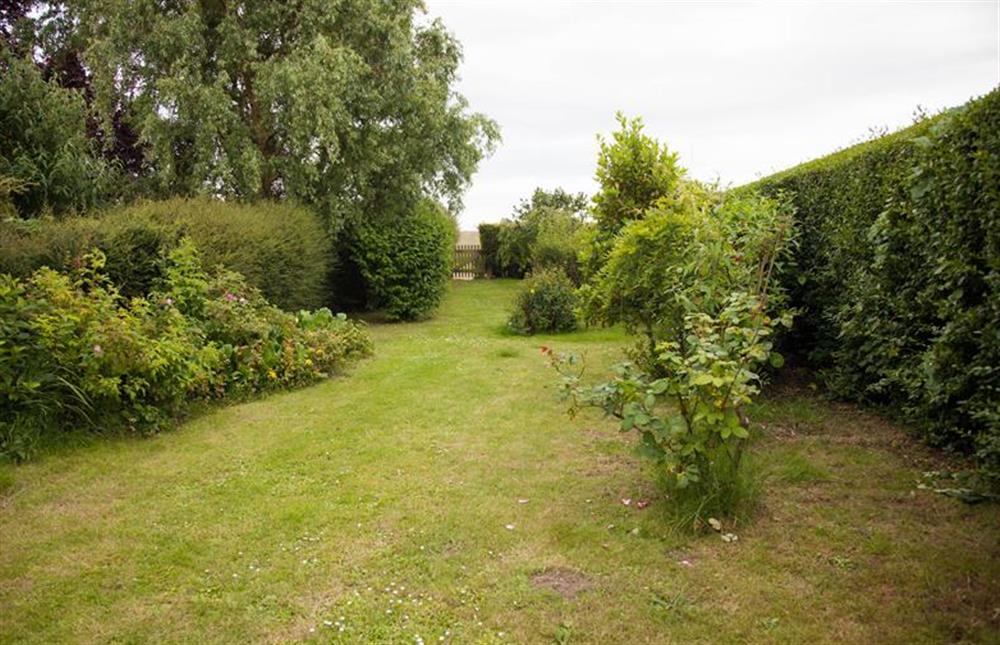 The garden has a gate which leads out into the open countryside at Plunketts Cottage, Brancaster near Kings Lynn