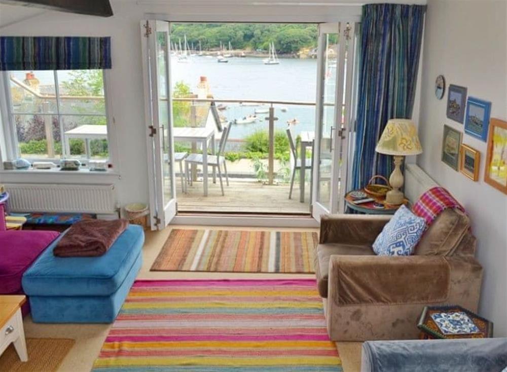 Colourful sitting room with patio doors leading to the large balcony at Polbathic in Fowey, Cornwall