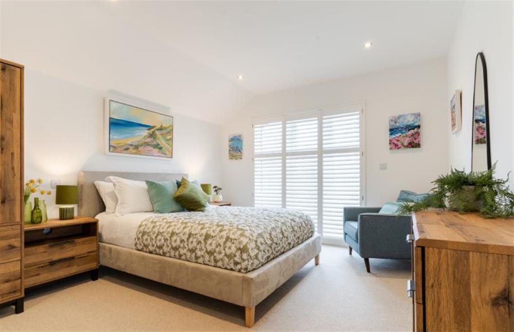 Bedroom one with a 5’ king-size bed and balcony access at Polberro Cottage, St Agnes