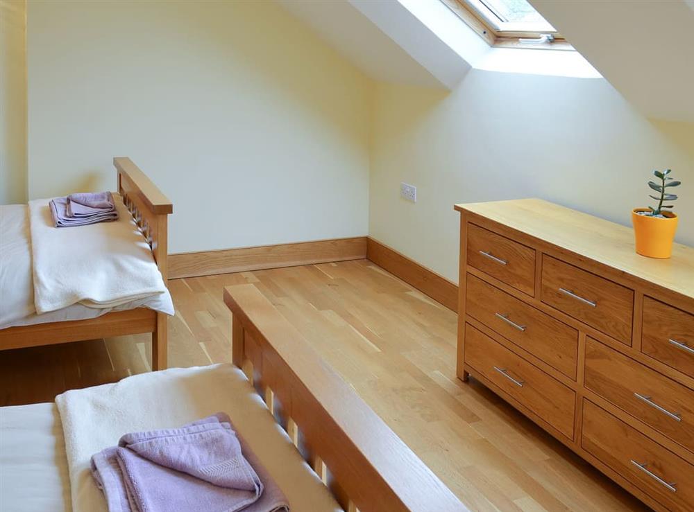 Twin bedrom flooded with natural light from a Velux window