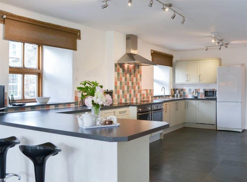 Large fitted kitchen with breakfast bar at Polmear Barn in Tregoodwell, Camelford, Cornwall., Great Britain