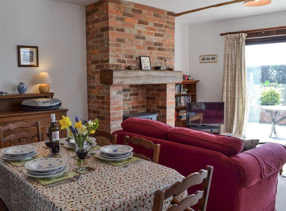 Living room with dining area at Pond Cottage in Peasmarsh, near Rye, East Sussex