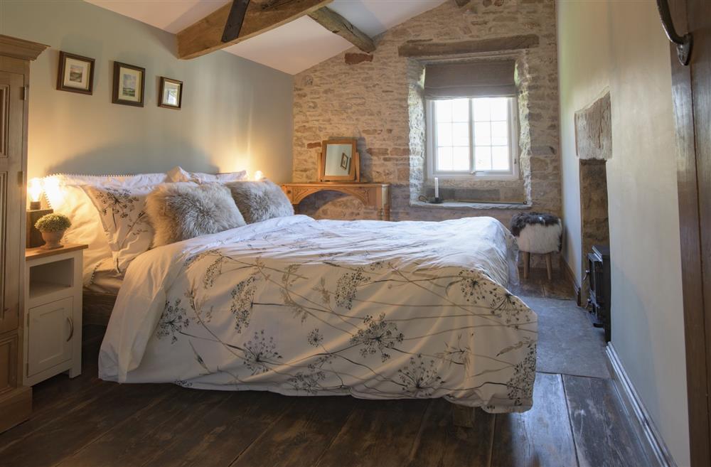 Master bedroom featuring exposed beams, original floor boards and Hobbit stove at Pond Cottage, West Witton, Leyburn, North Yorkshire