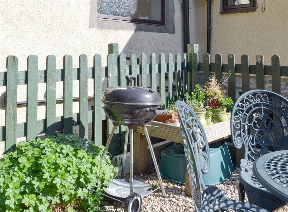 Outdoor furniture and BBQ on gravelled patio at Poppy Cottage in Bonsall, near Matlock, Derbyshire, England