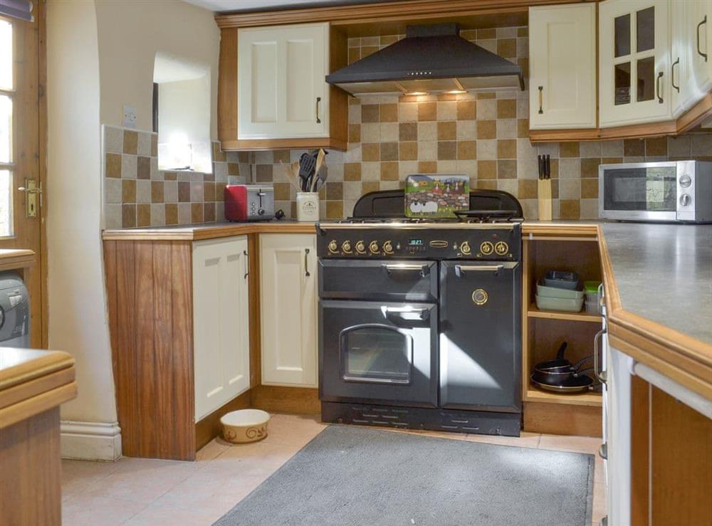 Well-equipped fitted kitchen with modern range-style cooker at Poppy Cottage in Bonsall, near Matlock, Derbyshire, England
