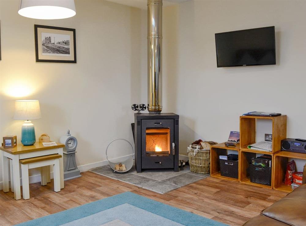 Cosy living area with wood burner at Porthole Cottage in Allonby, near Maryport, Cumbria
