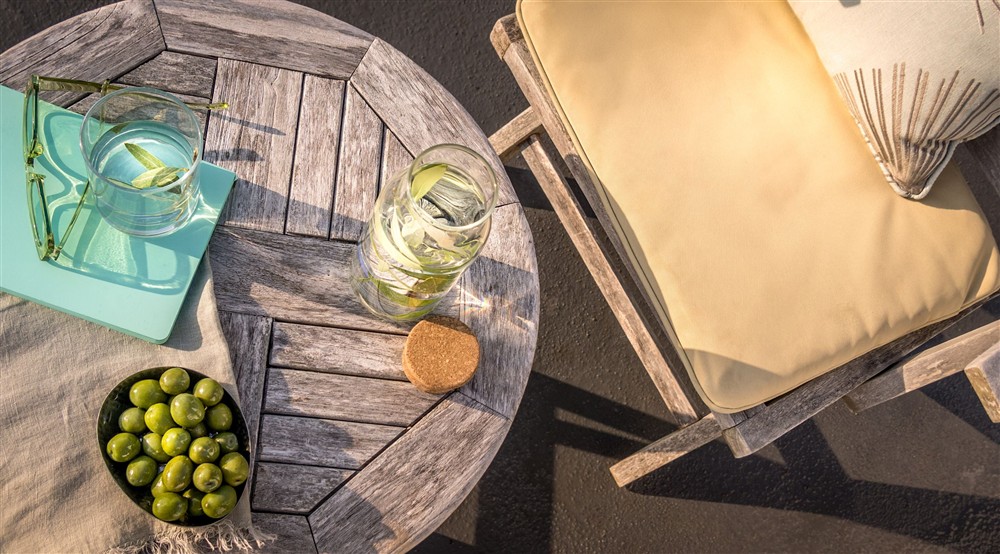 An outdoor table and chair on the upper terrace at Portland House in Weymouth, Dorset