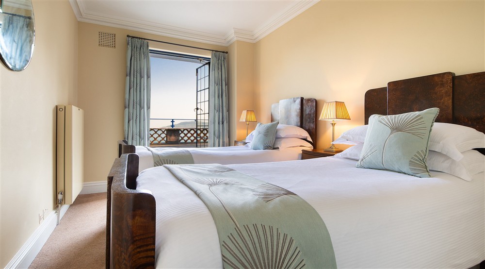 The twin bedroom on the first floor of Portland House, with patio doors to the upper terrace, Dorset at Portland House in Weymouth, Dorset