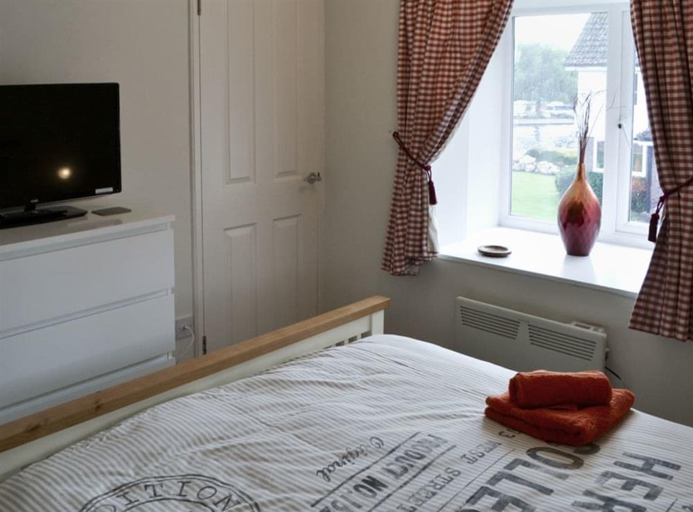 Tastefully furnished bedroom with king-size bed and Freeview TV at Pottergate Cottage in Wroxham, Norfolk