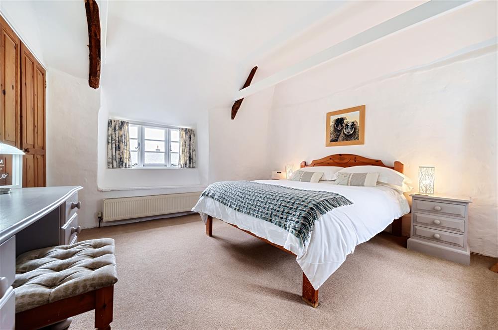 Bedroom one with a 5’ king-size bed, ample storage including fitted wardrobes at Primrose Cottage, Drewsteignton