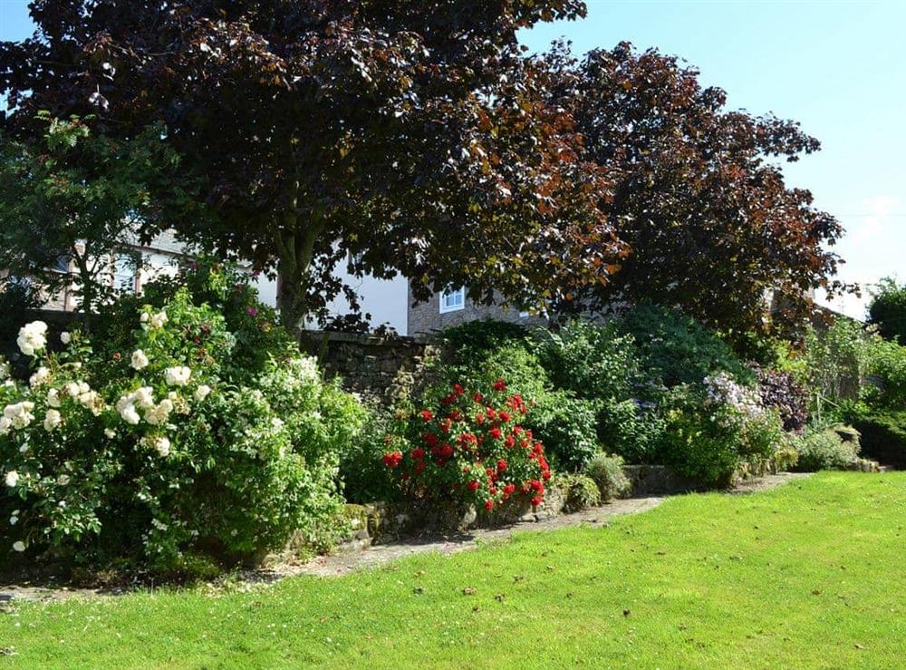 Beautiful garden with lush borders and mature trees at Primrose Cottage in Nr Keswick, Cumbria., Great Britain