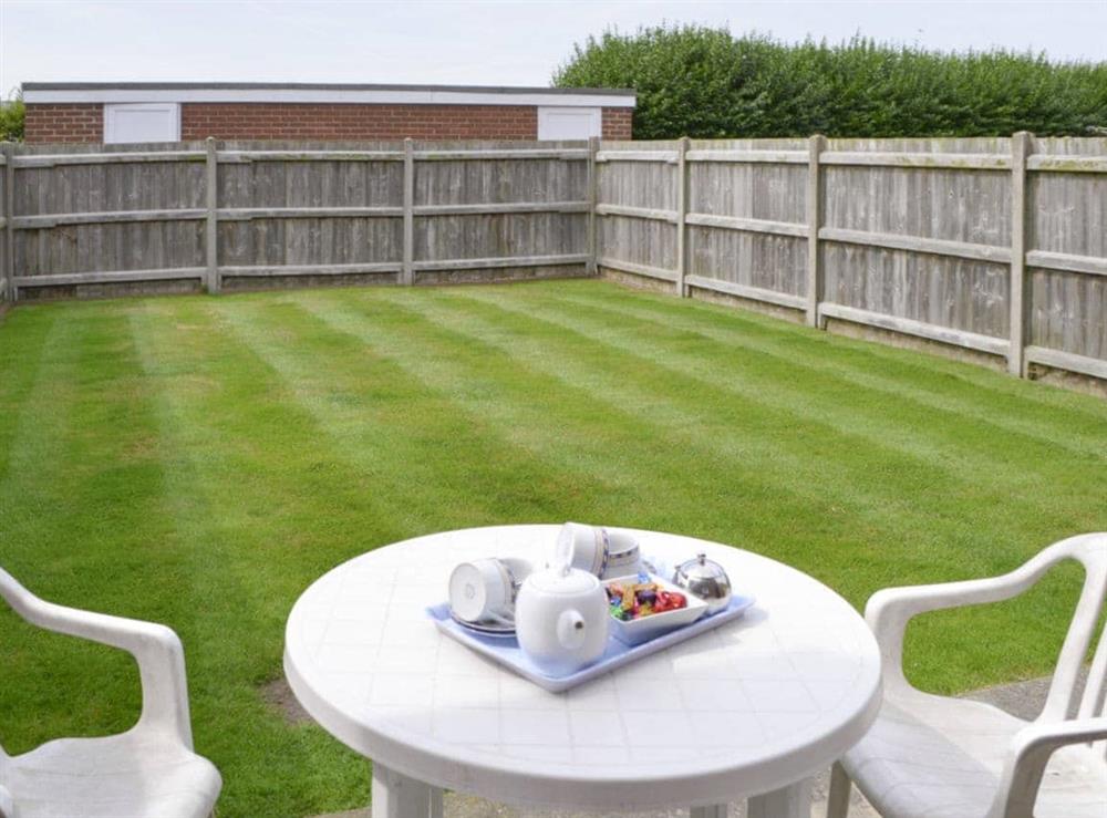 Enclosed rear garden with paved patio area at Primrose Cottage in Sea Palling, Norfolk