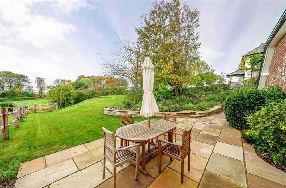 Enjoy sitting on the garden terrace overlooking the lawn at Puddle Cottage, Dorchester