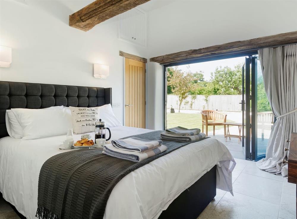 Stylishly furnished double bedroom with kingsize bed at Puddledock Piggery in Berkley, near Frome, Somerset