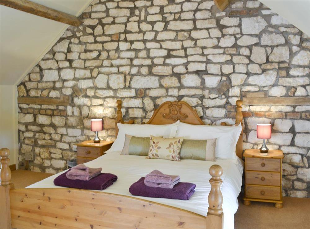 Exposed stone feature wall in double bedroom at Puffin Cottage in Buckton, near Flamborough, North Humberside