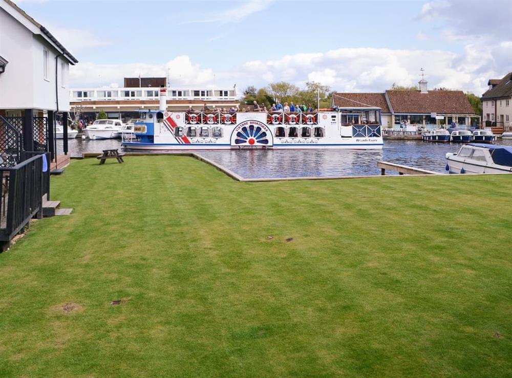 Delightful landscaped lawn with views along the river at Puffin Cottage in Wroxham, Norfolk