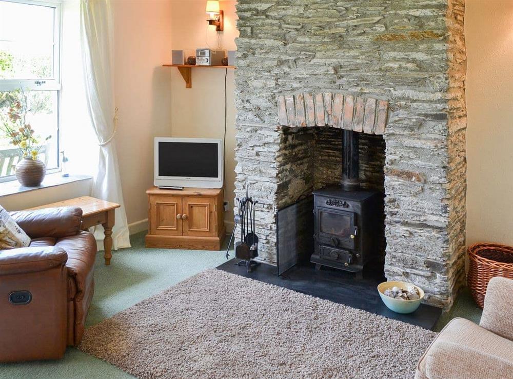 Warm and welcoming living room with wood burner at Quarrymans Cottage in Edmonton, near Wadebridge, Cornwall