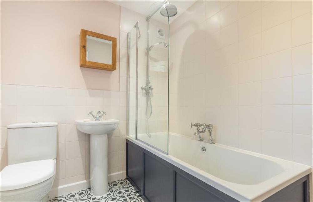 First floor: Bathroom with bath and shower overhead at Quay View Cottage, Wells-next-the-Sea