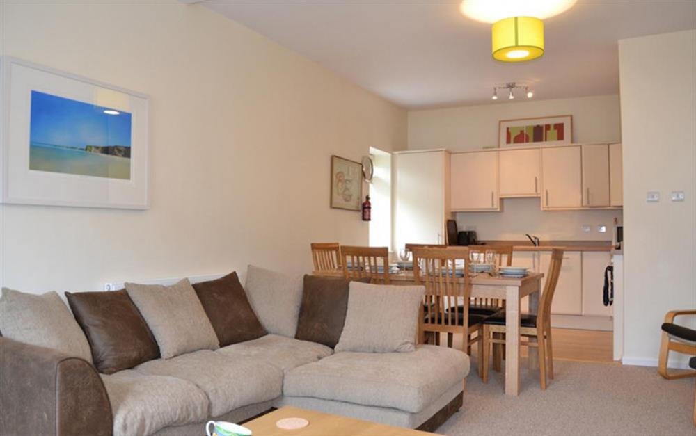 The open plan sitting room with the kitchen/diner in the background at Quayside Flat in Looe