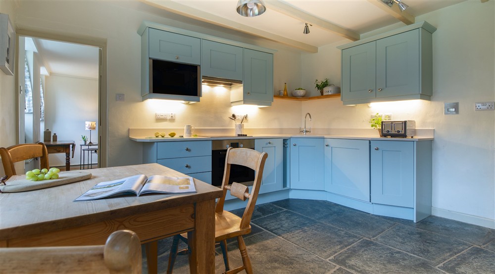 The kitchen with a table for three (photo 2) at Quin Cottage in Port Quin, Cornwall