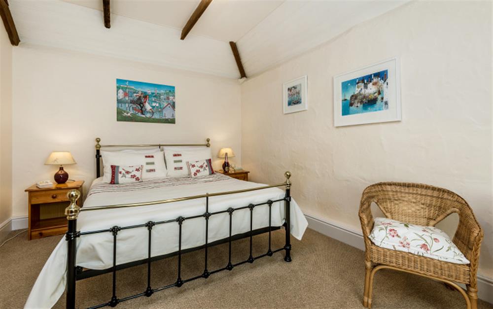 The bedroom has retained some of its original features including the ceiling beams. at Rainbow Cottage in Porthallow